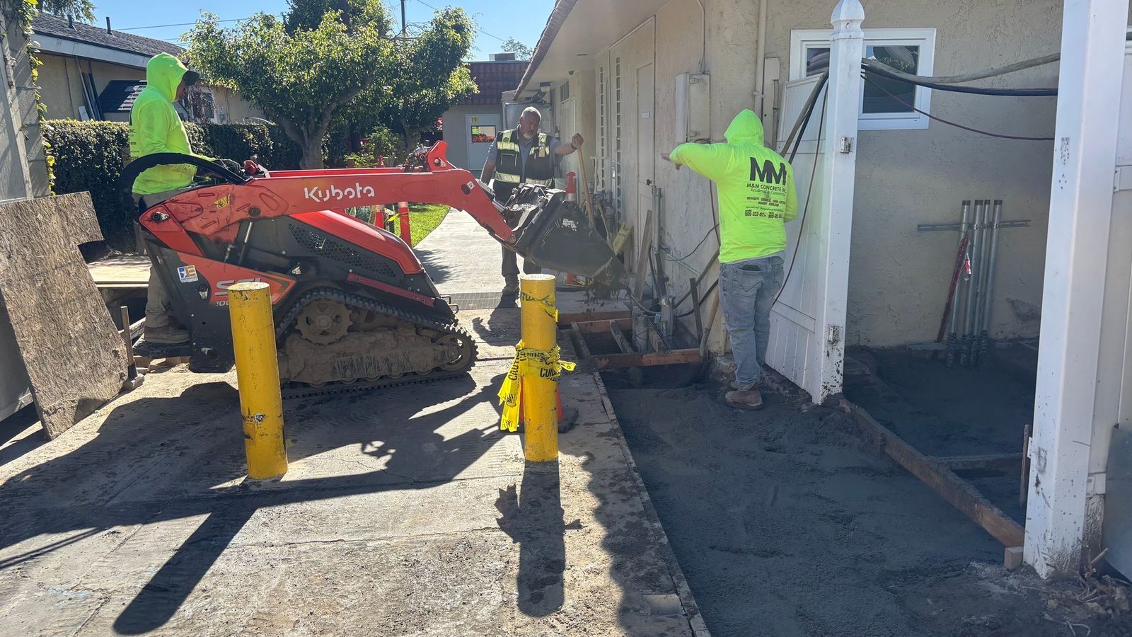 Kubota SCL1000 mini track loader working a tight side yard